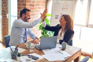 Professionnels souriants assis autour d'une table illustrant la réussite dans le développement de projets