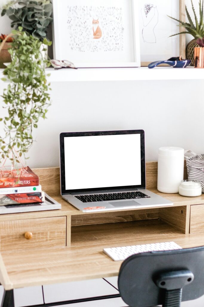 Bureau minimaliste avec ordinateur portable allumé, illustrant la collaboration à distance et l’externalisation pour entreprises et associations.
