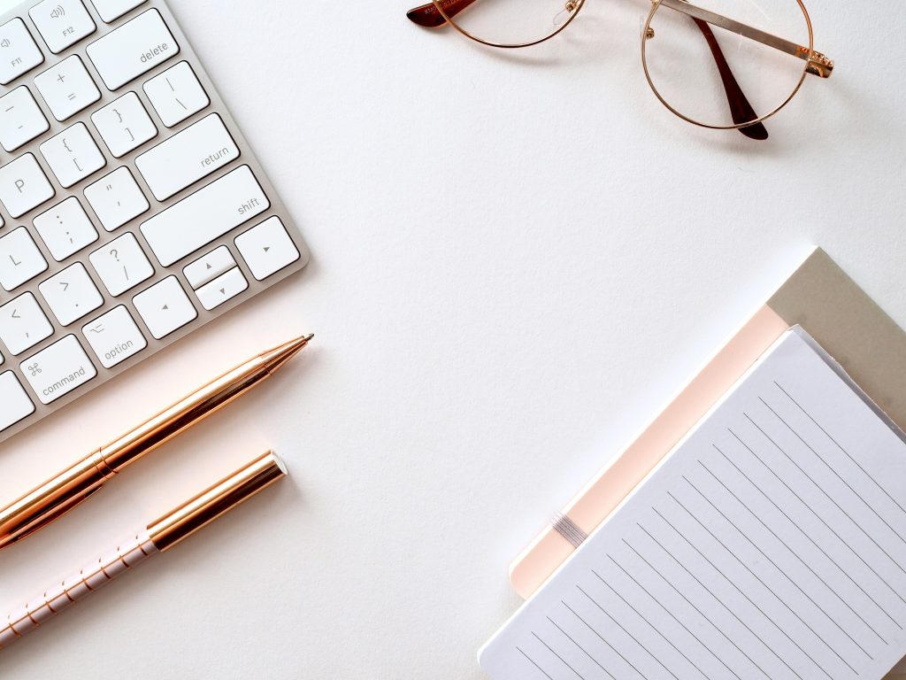 Bureau organisé avec clavier, carnet et lunettes symbolisant la clarté et le pilotage d’activité des dirigeants de TPE-PME.