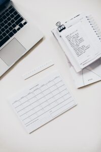 table de travail avec ordinateur et notes illustrant les astuces pour rédiger des comptes rendus de réunions dans les meilleurs conditions